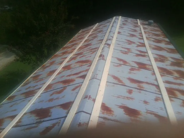 Rusted metal roof panels with new wood purlins before replacement — Storm Damage Roof Repair in Kingsland by Roofing Brothers