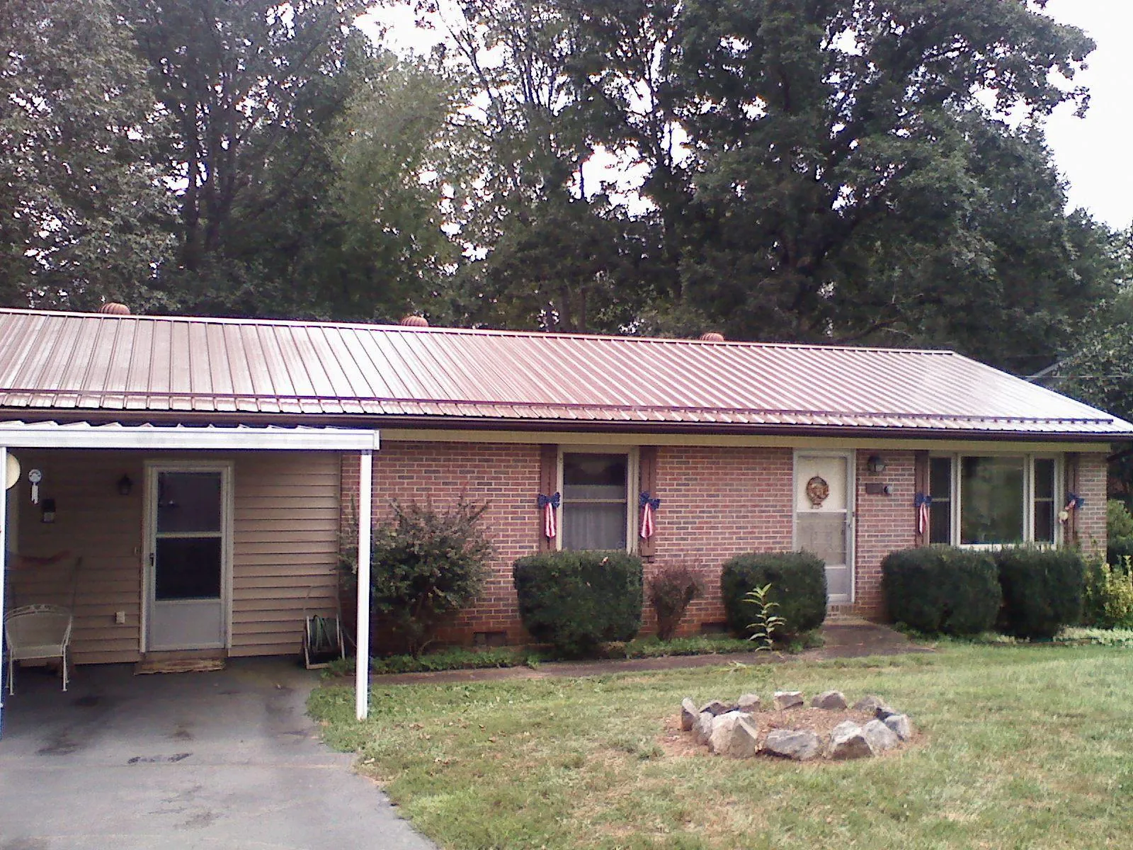 Bronze metal roof and carport on a brick ranch home — Roof Repair work by our crew in Kingsland